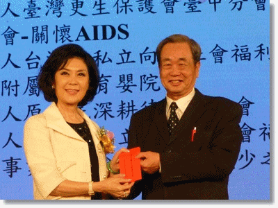 白嘉莉小姐於年會中親自將捐款捐贈予臺中更保王主任委員錦賜